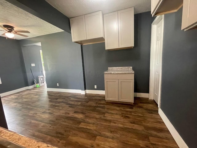 kitchen featuring white cabinetry, ceiling fan, dark hardwood / wood-style floors, and a textured ceiling