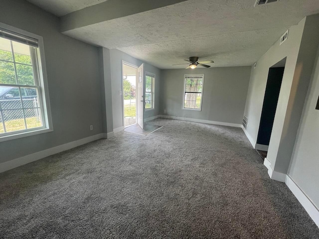 spare room featuring ceiling fan, carpet flooring, and a textured ceiling