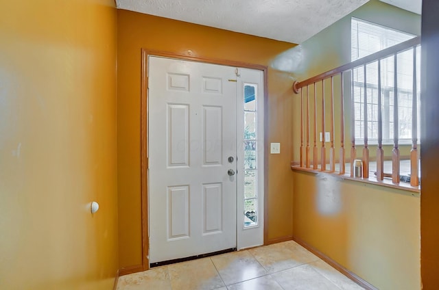 tiled foyer entrance featuring a textured ceiling