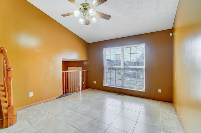 tiled spare room featuring ceiling fan, vaulted ceiling, and a textured ceiling