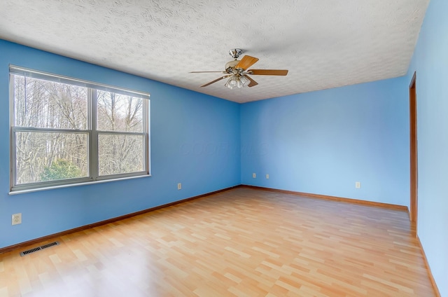 spare room featuring ceiling fan, a textured ceiling, and light wood-type flooring