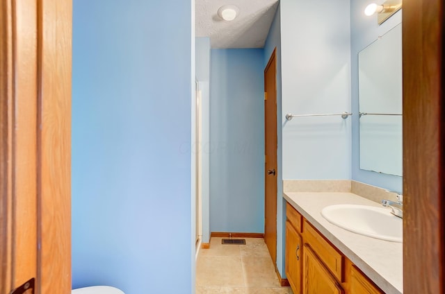 bathroom featuring vanity, tile patterned floors, and a textured ceiling