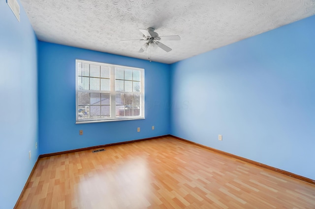 empty room with hardwood / wood-style floors, a textured ceiling, and ceiling fan