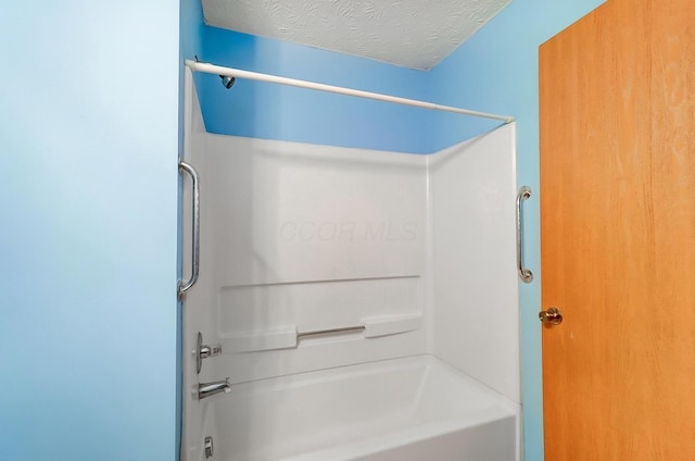 bathroom featuring shower / washtub combination and a textured ceiling