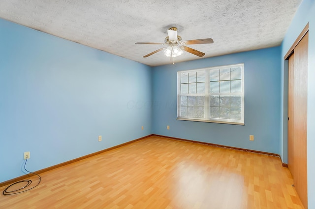 unfurnished bedroom with light hardwood / wood-style floors, a closet, and a textured ceiling