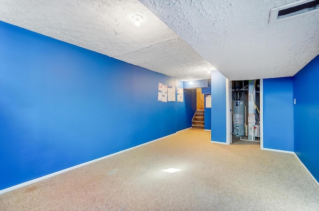 basement featuring carpet, water heater, and a textured ceiling