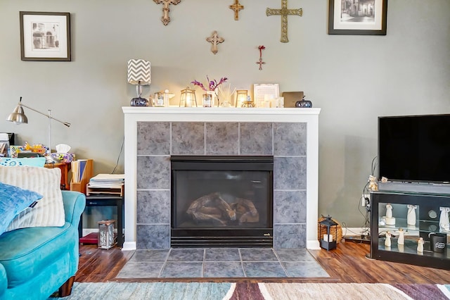 details featuring wood-type flooring and a tiled fireplace