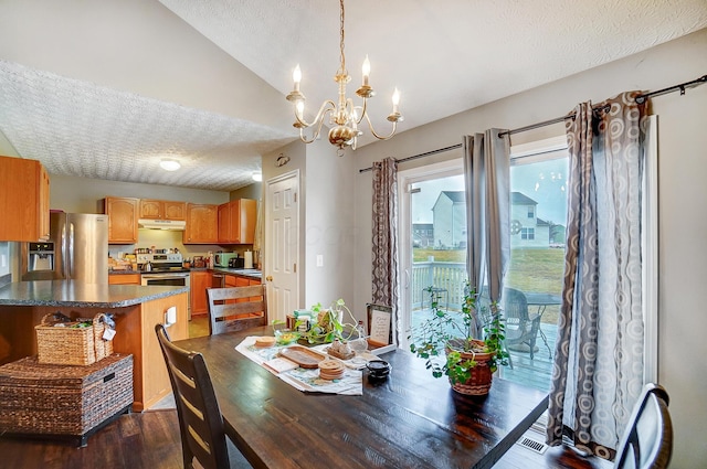 dining room featuring vaulted ceiling, dark wood-type flooring, a chandelier, and a textured ceiling