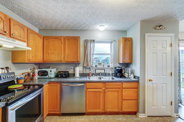 kitchen with stainless steel appliances, sink, and a textured ceiling