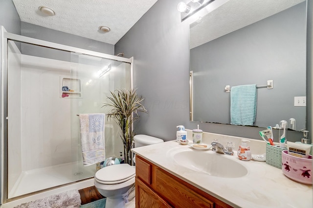 bathroom with vanity, toilet, an enclosed shower, and a textured ceiling