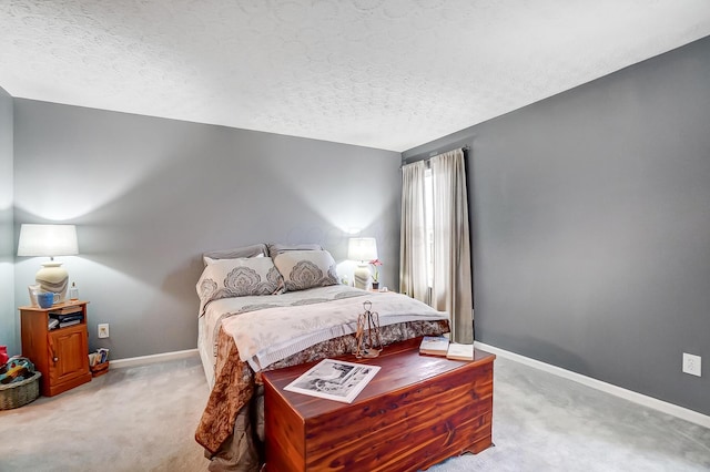 bedroom featuring light carpet and a textured ceiling