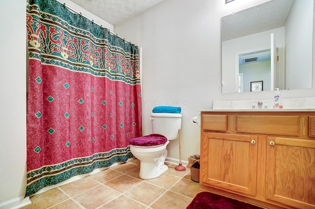 bathroom featuring vanity, tile patterned floors, a textured ceiling, and toilet