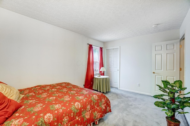 bedroom featuring light carpet and a textured ceiling