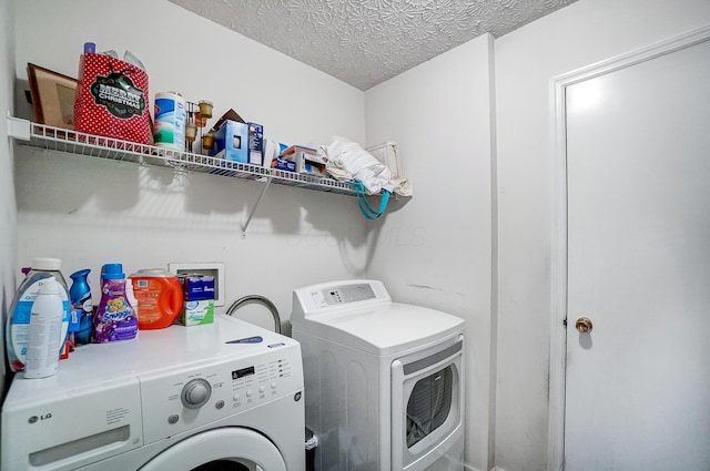 laundry area with washer and clothes dryer and a textured ceiling