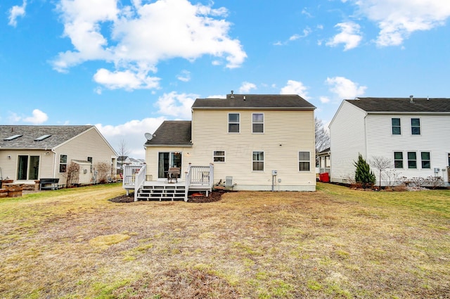 back of property featuring a deck and a lawn