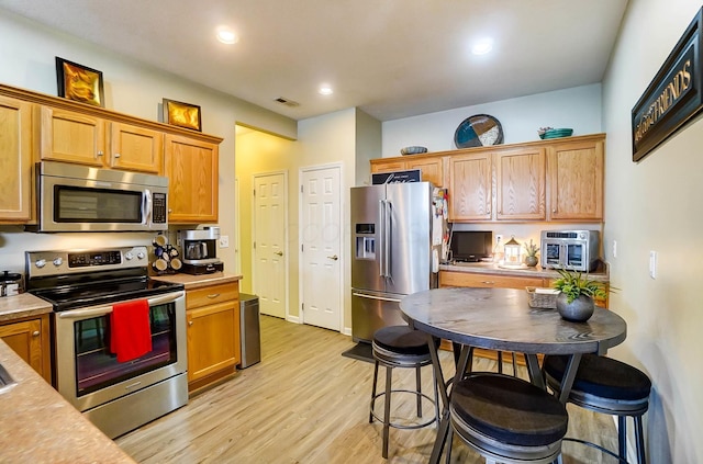 kitchen featuring light wood-type flooring and appliances with stainless steel finishes