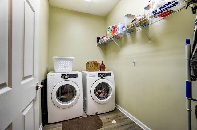 laundry room featuring wood-type flooring and separate washer and dryer