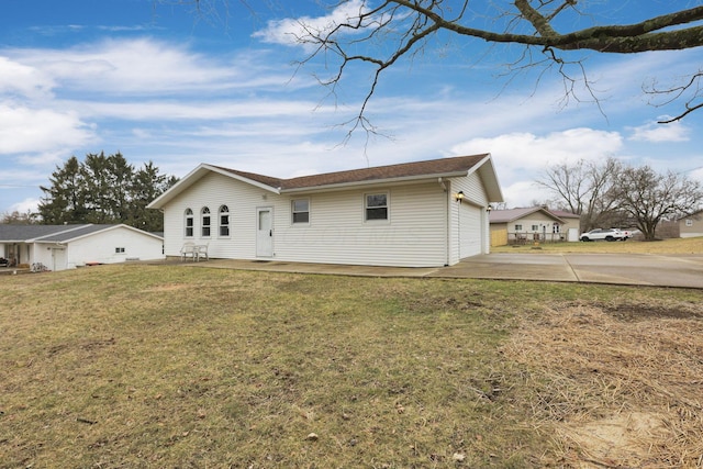 back of house with a garage and a lawn