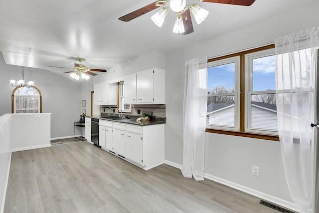 kitchen with sink, white cabinetry, tasteful backsplash, black dishwasher, and light hardwood / wood-style floors