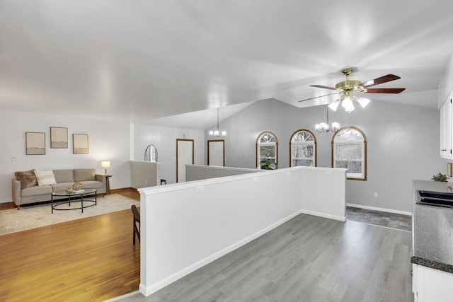 kitchen featuring hardwood / wood-style flooring, vaulted ceiling, hanging light fixtures, and white cabinets