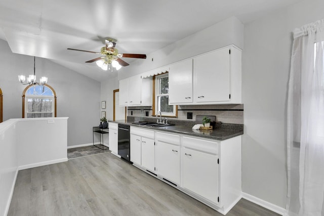 kitchen featuring lofted ceiling, sink, dishwasher, and white cabinets