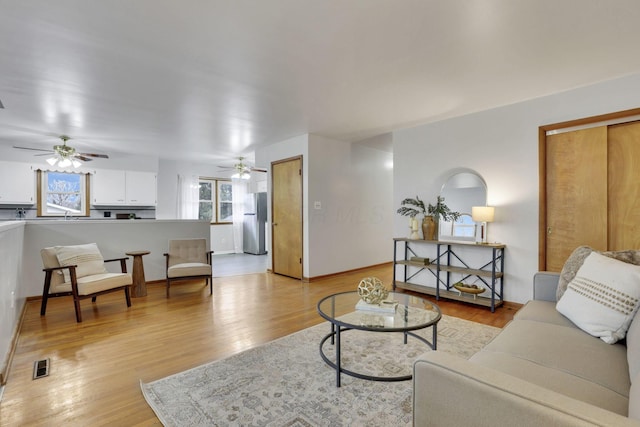 living room with light hardwood / wood-style floors and ceiling fan