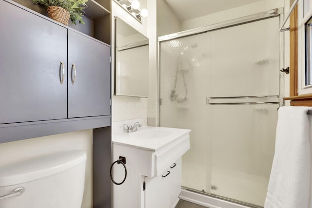 bathroom featuring vanity, an enclosed shower, and toilet