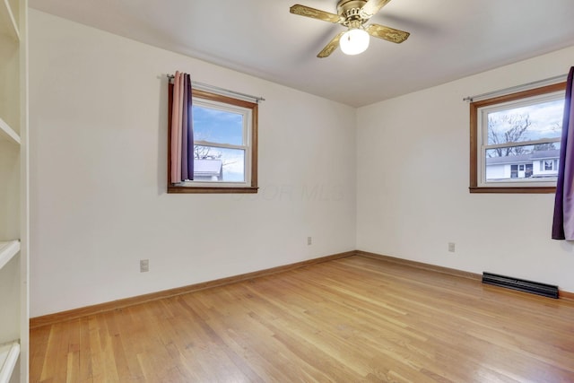 empty room with a healthy amount of sunlight, ceiling fan, and light hardwood / wood-style flooring