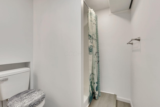 bathroom with hardwood / wood-style flooring and toilet