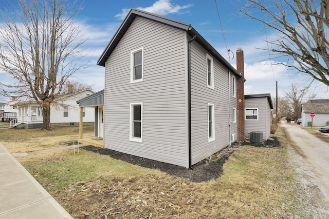 view of side of property featuring a yard and cooling unit