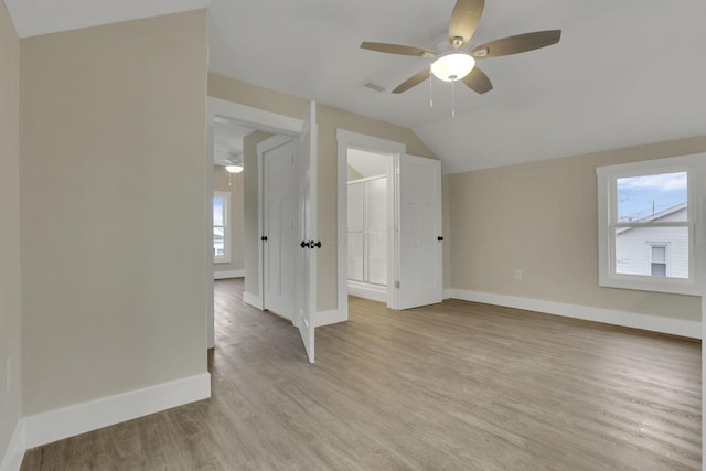 unfurnished room featuring ceiling fan, vaulted ceiling, light hardwood / wood-style flooring, and a wealth of natural light