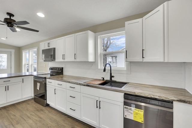 kitchen featuring sink, appliances with stainless steel finishes, white cabinetry, hardwood / wood-style floors, and a healthy amount of sunlight