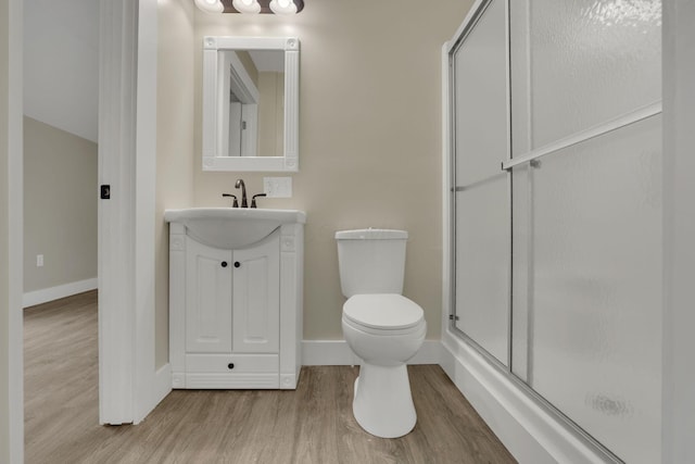 bathroom with a shower with door, wood-type flooring, vanity, and toilet