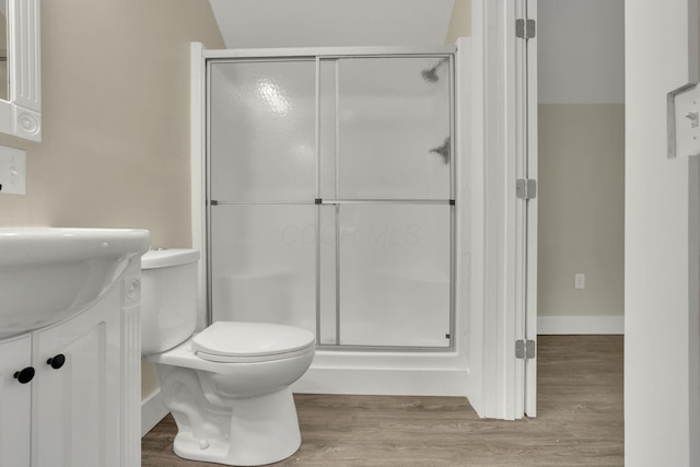 bathroom featuring hardwood / wood-style flooring, vanity, toilet, and a shower with shower door