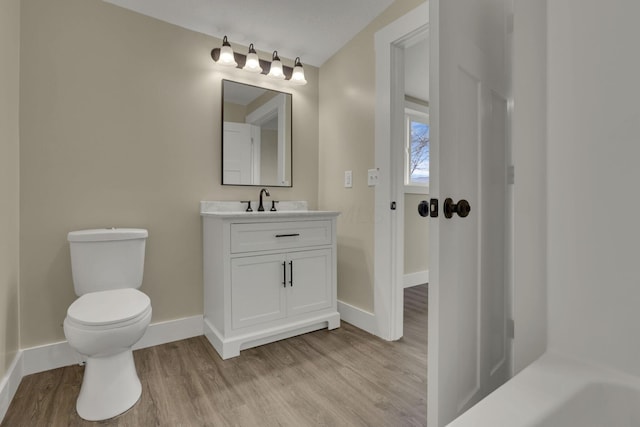 bathroom with hardwood / wood-style flooring, vanity, and toilet