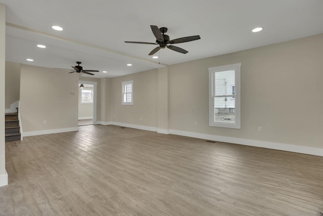 spare room with ceiling fan and light wood-type flooring