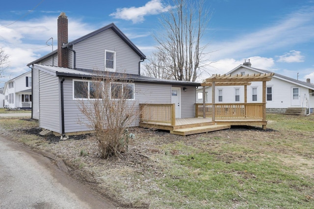 back of house featuring a wooden deck and a pergola