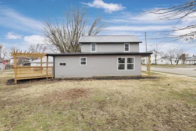 back of property featuring a wooden deck, a pergola, and a lawn