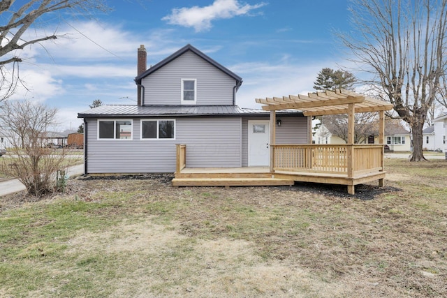 rear view of house featuring a wooden deck, a lawn, and a pergola