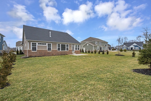 rear view of house featuring a lawn and a patio