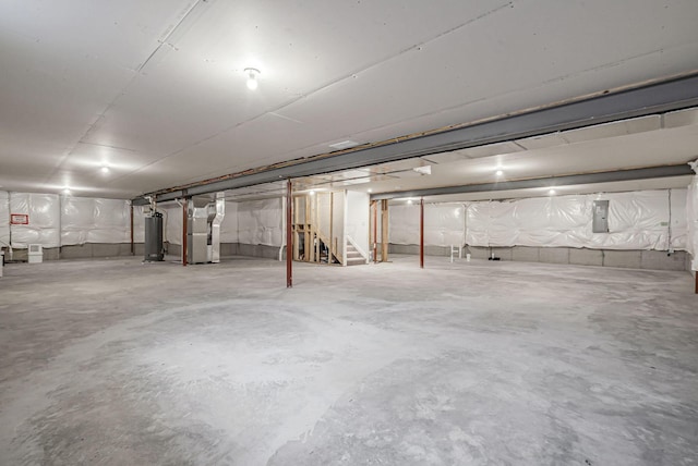 basement featuring heating unit, gas water heater, and electric panel