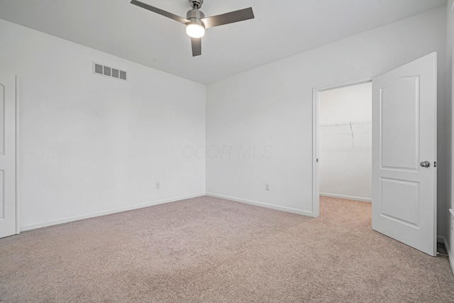 spare room featuring light carpet and ceiling fan