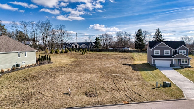 view of yard with a garage and central AC unit