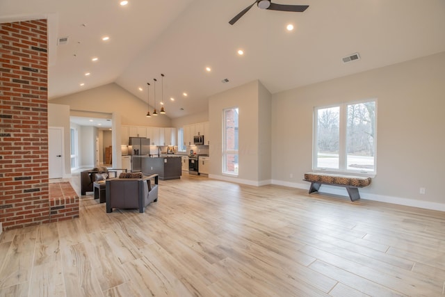 living room featuring ceiling fan, high vaulted ceiling, and light hardwood / wood-style flooring