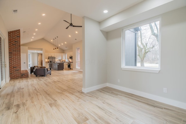 unfurnished living room with ceiling fan, high vaulted ceiling, and light wood-type flooring