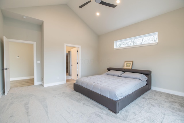 carpeted bedroom featuring ceiling fan, high vaulted ceiling, and ensuite bath