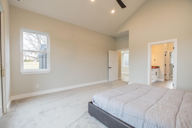 bedroom featuring connected bathroom, light carpet, and high vaulted ceiling