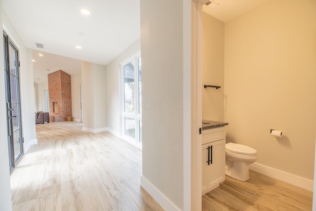 bathroom featuring vanity, hardwood / wood-style floors, and toilet