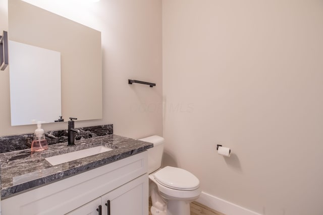 bathroom with vanity, wood-type flooring, and toilet