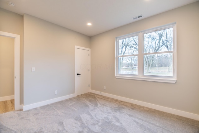 spare room with light carpet and a healthy amount of sunlight